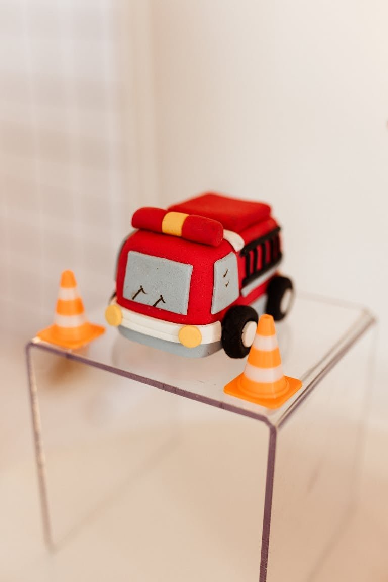 Bright toy fire truck displayed with traffic cones in a playful setting.